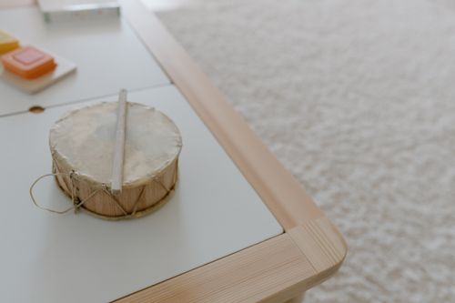 Free A children's drum placed on a wooden table in a cozy playroom setting. Stock Photo