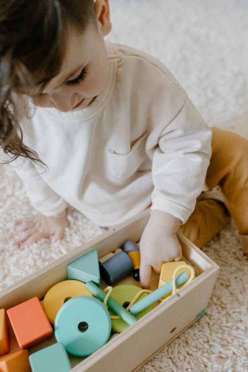 A Cute Little Child Playing Colorful Wooden Toys 