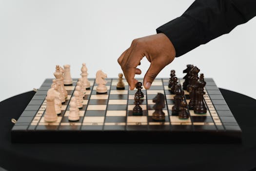 A close-up view of a hand playing chess, focusing on strategy and decision-making.
