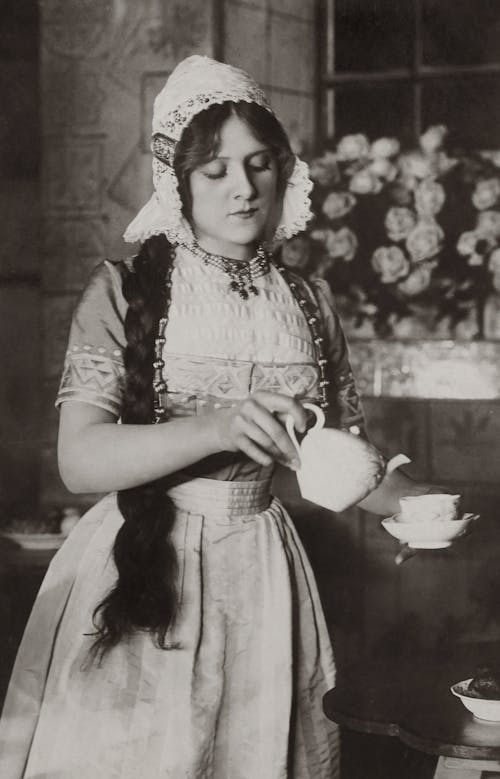 Old Photo Of Woman Pouring Tea In A Cup