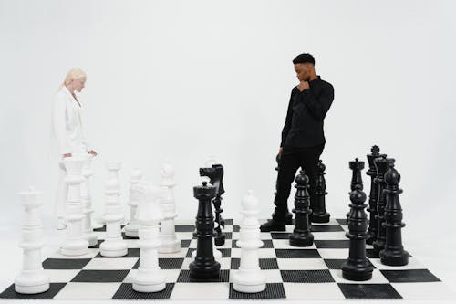 Free Two People Standing on a Giant Chess Board Stock Photo