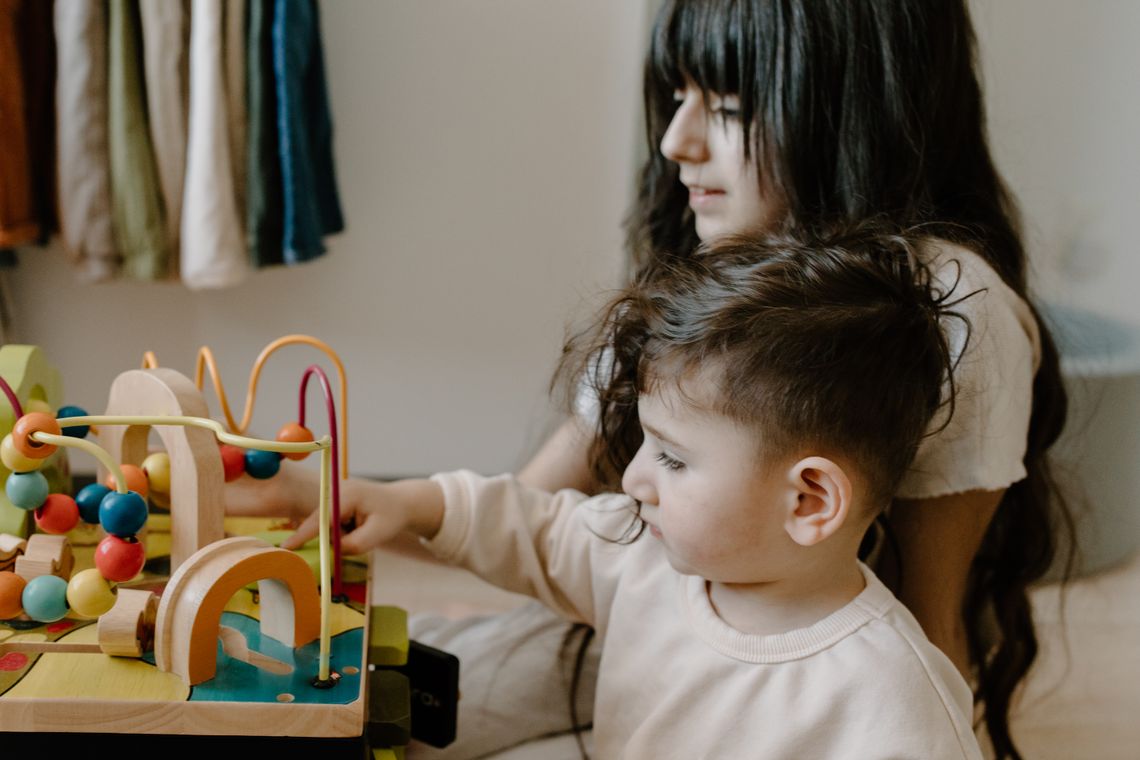 Two children learning together with wooden toys at a table