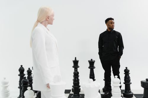 Free Two individuals strategize in a life-sized chess game, emphasizing competition and strategy. Stock Photo