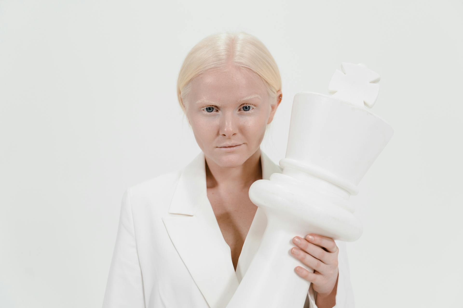 A Woman Holding a White Giant Chess Piece