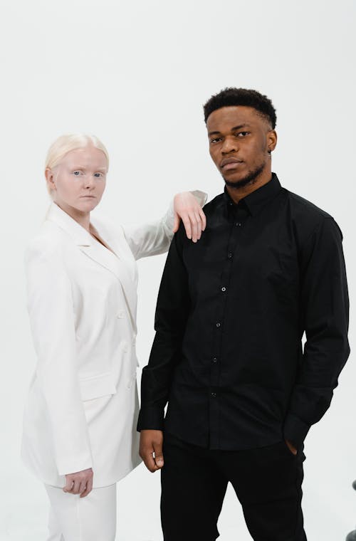 Woman in a Suit Standing Beside Man in Black Long Sleeve Top