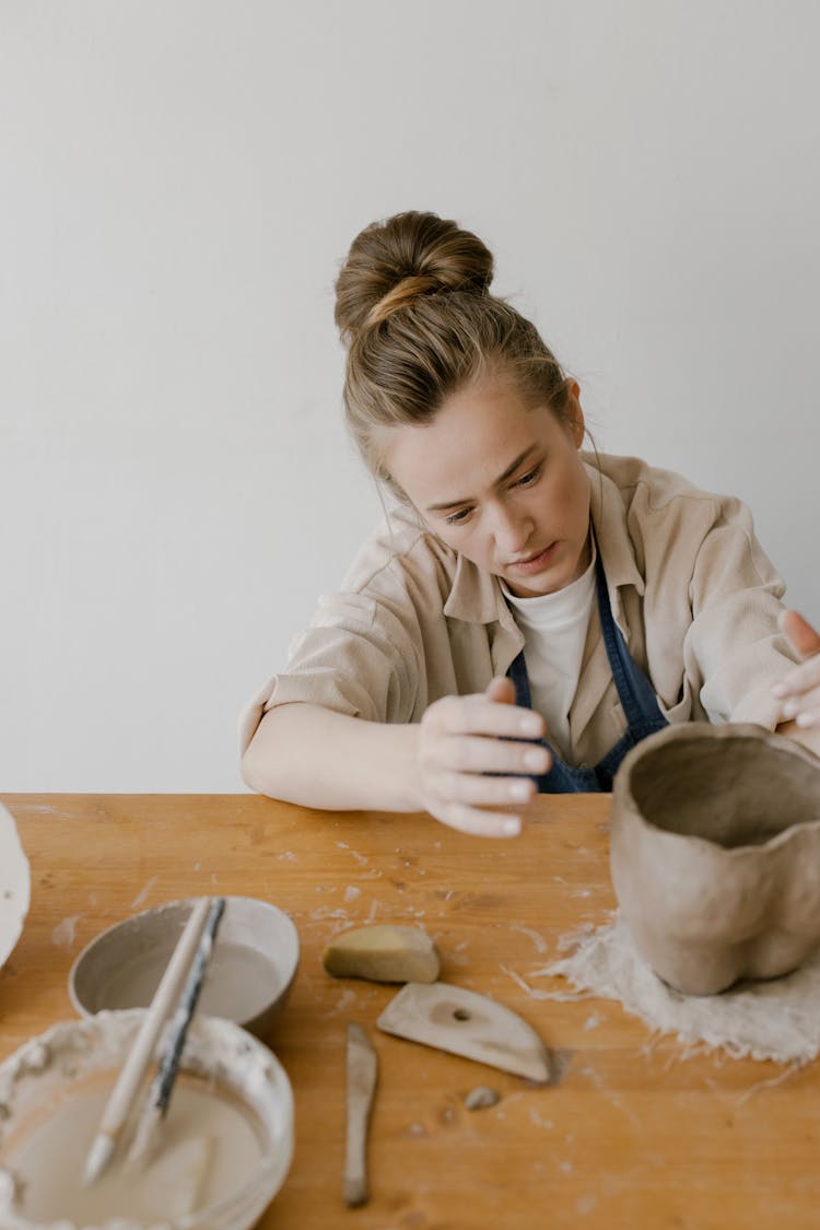 A Woman Molding A Clay