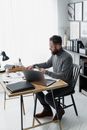 Man in Gray Sweater Sitting on Chair Using Laptop Computer