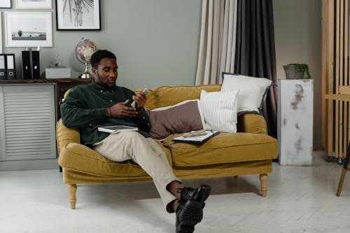 A Woman in Black Long Sleeves Sitting on the Couch while Holding Cash