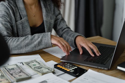 A Woman in Plaid Blazer Using Her Laptop