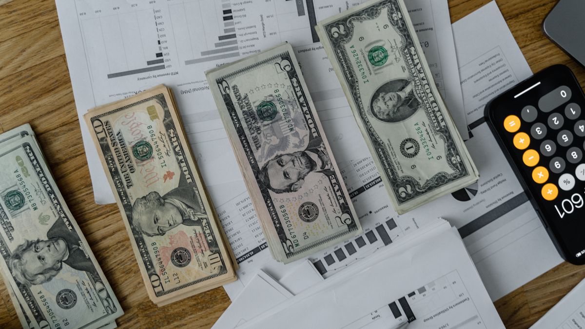 A workspace setup featuring cash, documents, and a calculator symbolizing financial analysis and budgeting.