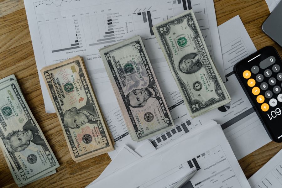 A workspace setup featuring cash, documents, and a calculator symbolizing financial analysis and budgeting.