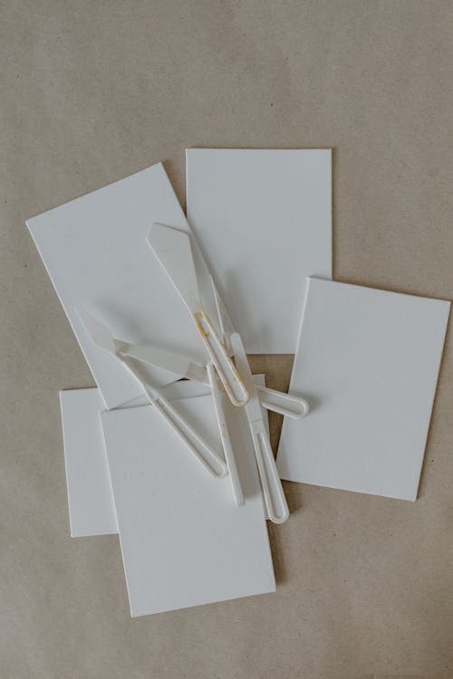 White Spatulas and White Cardboard on Brown Surface