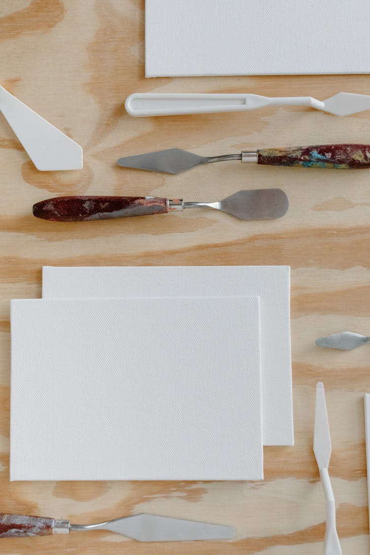 Painting Tools And Canvas Over Wooden Surface