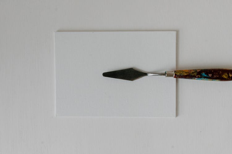 Close-Up Shot Of A Knife Painting On White Surface