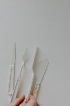Close-up of plastic palette knives on a neutral background.