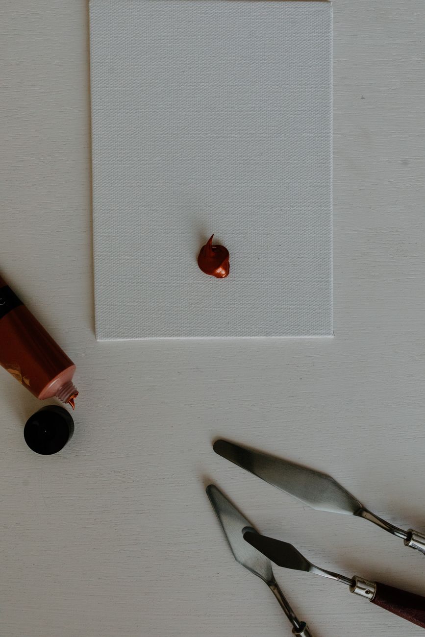 Acrylic paint and palette knives on a canvas ready for artistic creation.