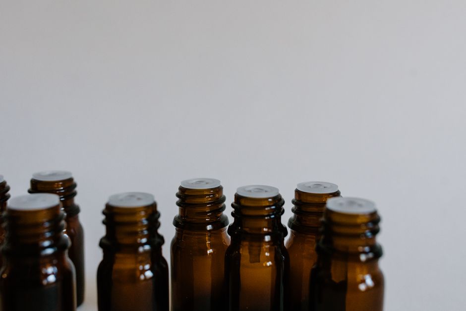 A serene, minimalist composition of brown glass bottles on a neutral background.