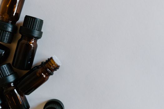 A minimalist arrangement of brown essential oil bottles on a white background, ideal for aromatherapy themes.