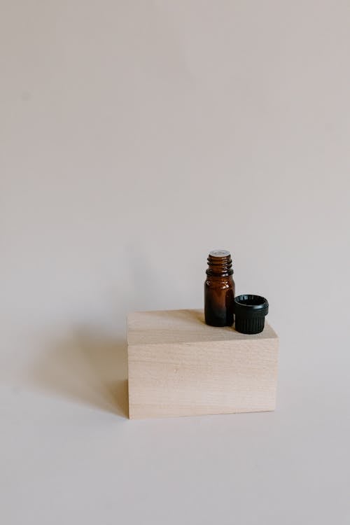 Close-Up Shot of an Essential Oil Bottle on Wooden Block