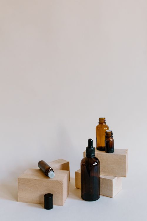 Free Stylish product display of essential oil bottles and droppers on wooden blocks, perfect for wellness branding. Stock Photo