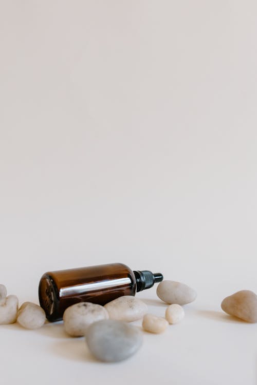 Free Essential Oil with Stones on White Surface Stock Photo