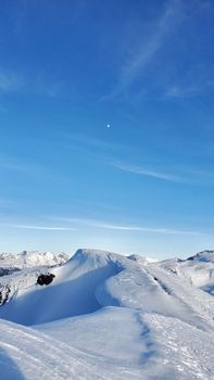 A breathtaking view of snow-covered mountain peaks against a clear blue sky.