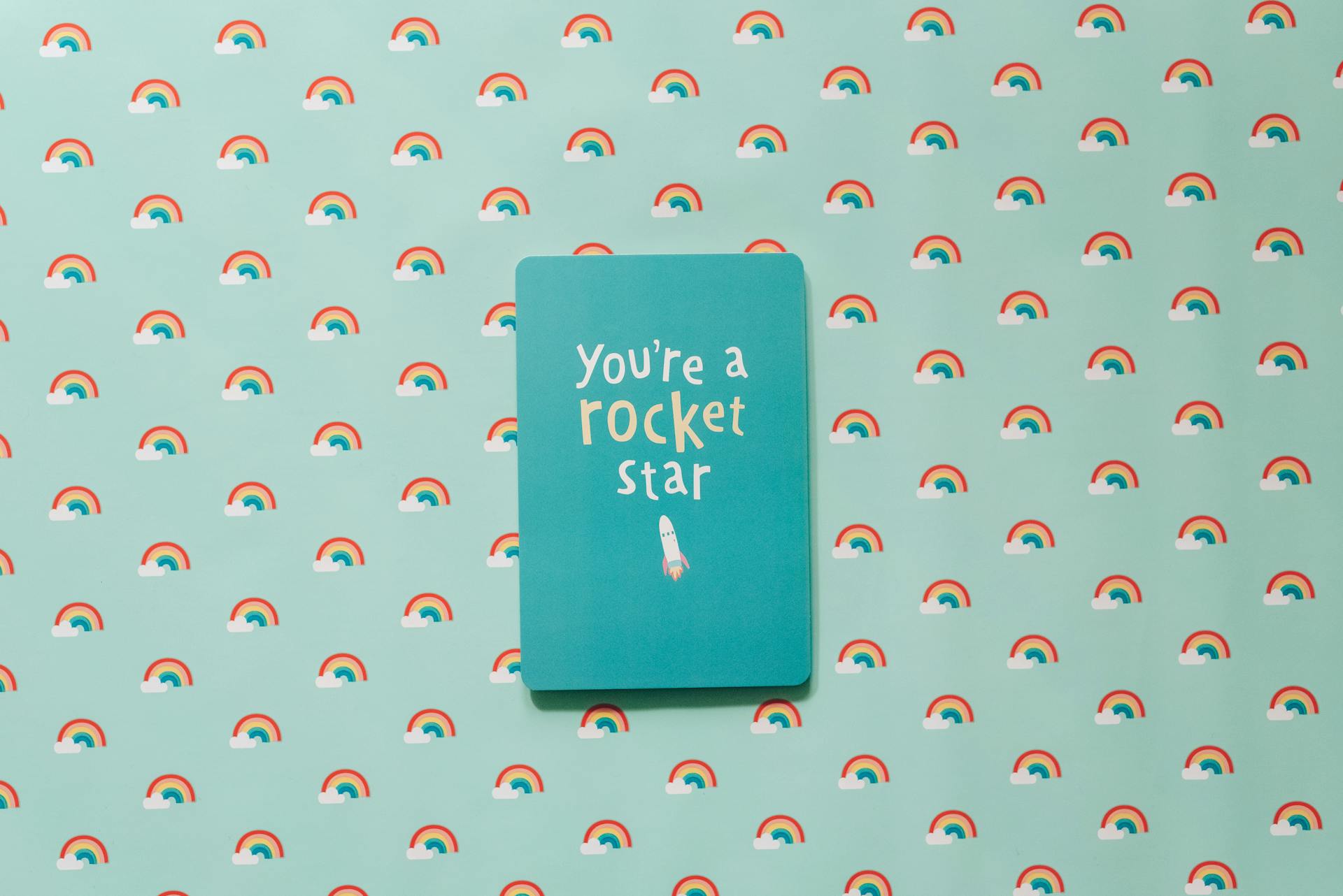 Inspirational card with 'You're a rocket star' text on a rainbow background.