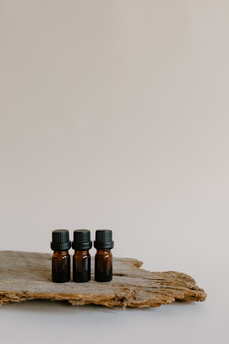 Small Amber Glass Bottles On Top Of A Wood 