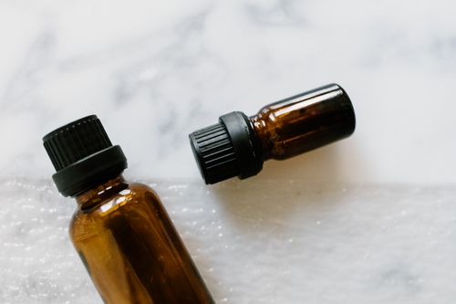 Free Close-up of brown glass essential oil bottles on marble surface, ideal for aromatherapy and wellness themes. Stock Photo