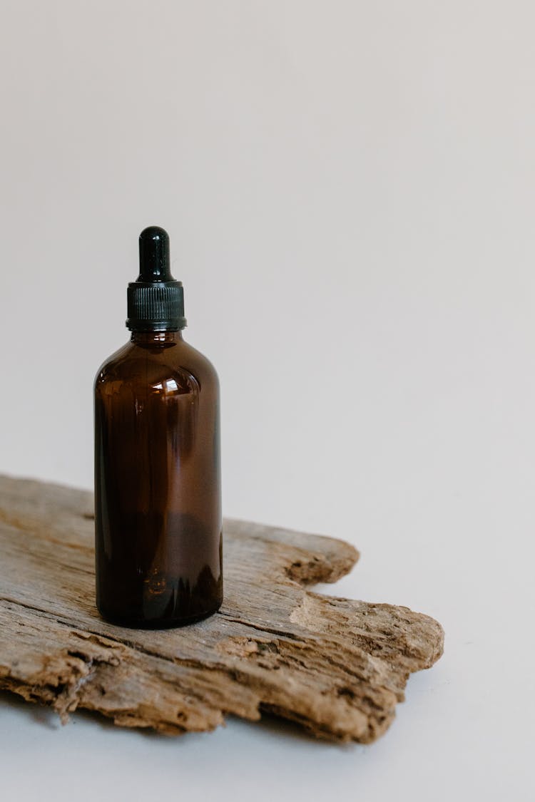 Close-Up Shot Of A Brown Dropper Bottle On A Wood