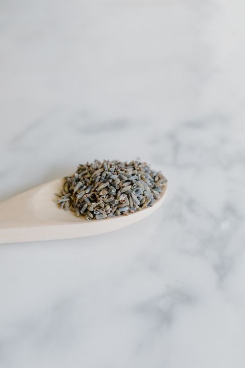 Free A close-up of dried lavender herbs on a wooden spoon against a white background. Stock Photo