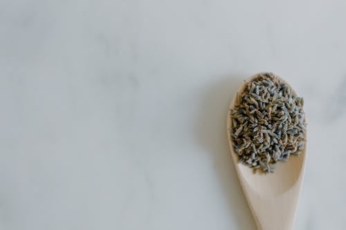 Free Top view of dried lavender in spoon placed on white marble surface in light room Stock Photo