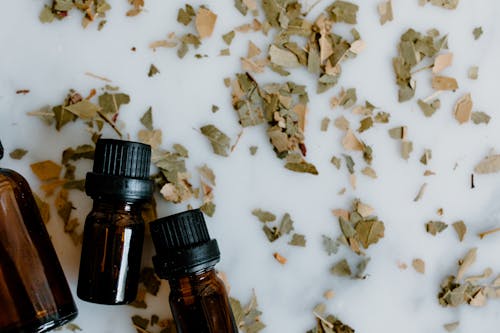 Free Essential Oil Bottles and Herbal Medicine on White Surface Stock Photo