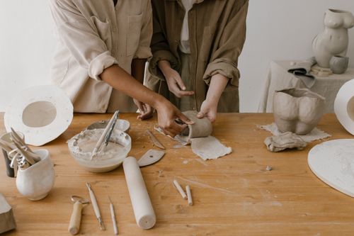 Free Two people handcrafting pottery, showing detailed craftsmanship and creativity. Stock Photo
