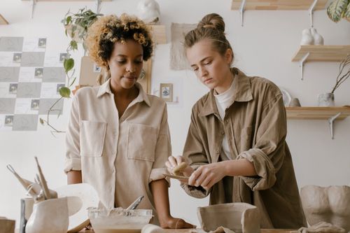 Free Two women engaging in pottery creation in an artistic workshop setting. Stock Photo