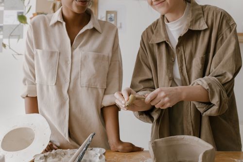 Free Two artisans craft pottery in a cozy workshop, engaging in creative collaboration. Stock Photo