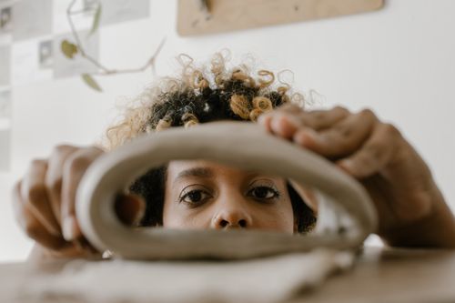 Free Close-up of a woman crafting with clay, highlighting artistic focus and craftsmanship. Stock Photo