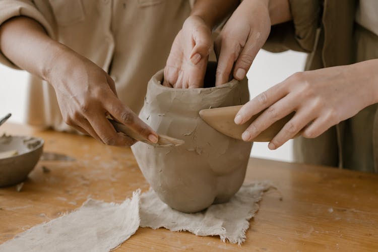 Shaping Clay Pots With Hands And Wood Knife