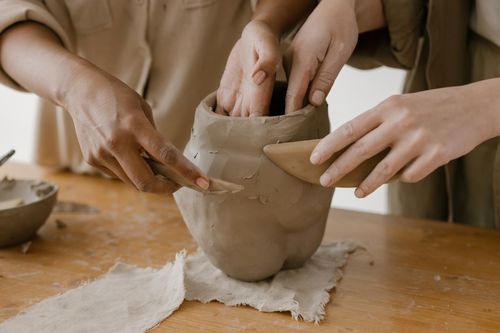 Free Hands shaping clay pottery collaboratively, showing craftsmanship. Stock Photo