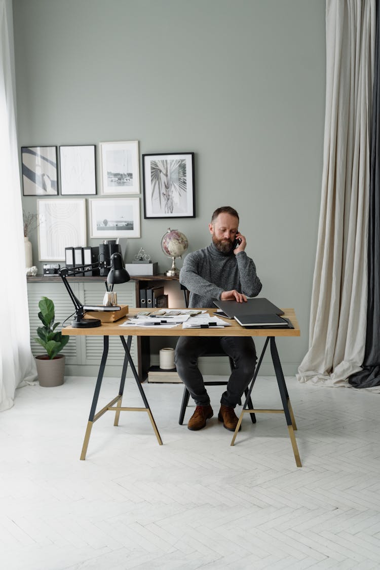 A Bearded Man Using Smartphone In The Office