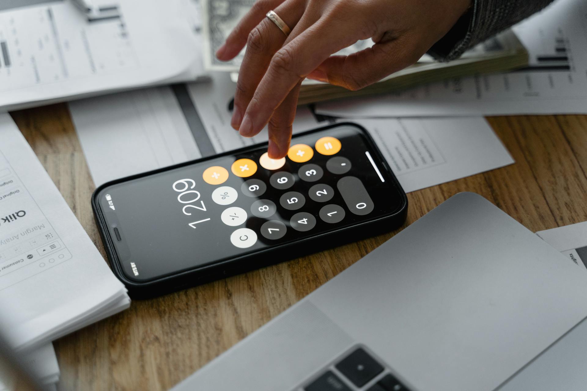 A Man with Wedding Ring Computing with a Mobile App Calculator