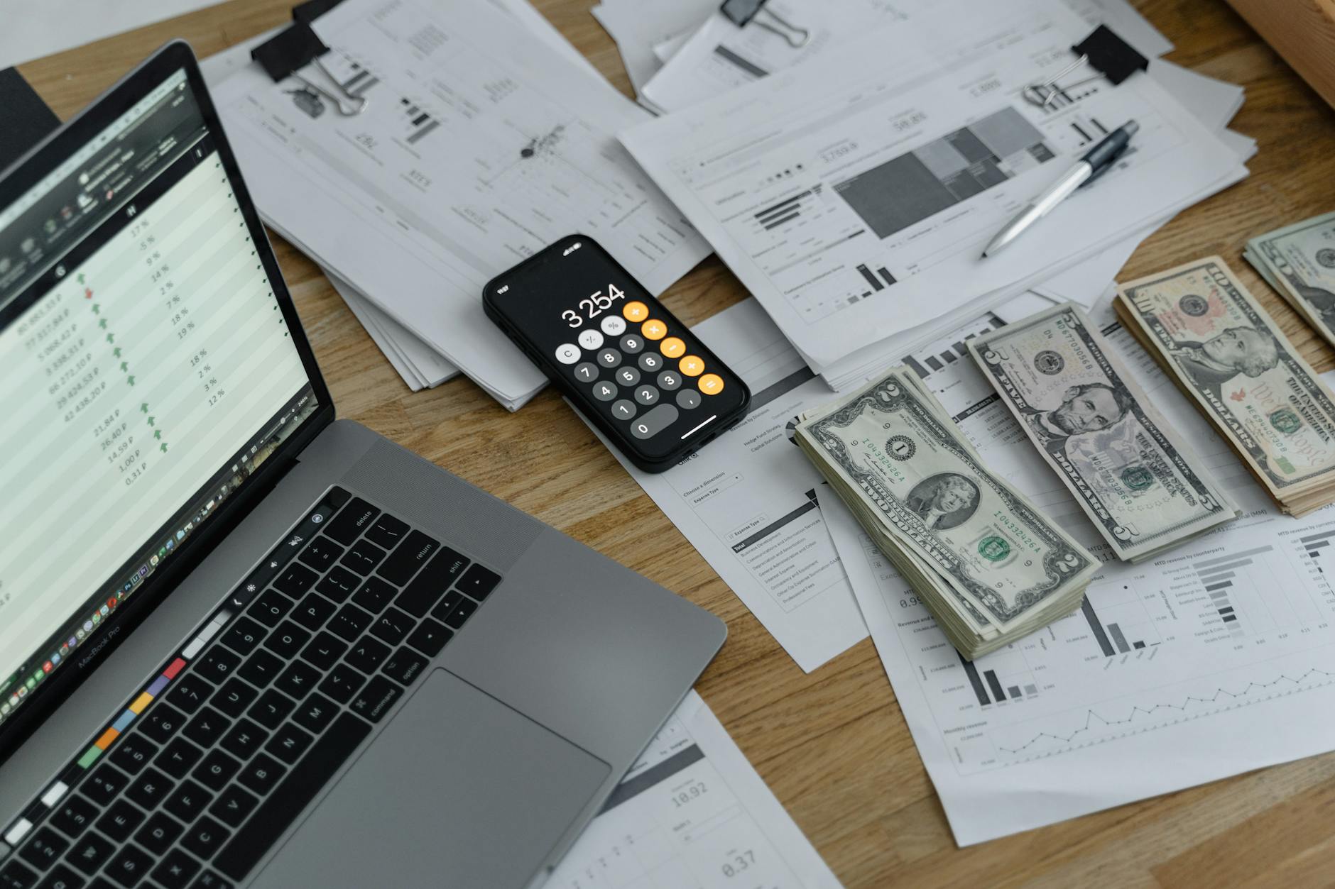 Foto Uang Kertas dan Kalkulator di Meja