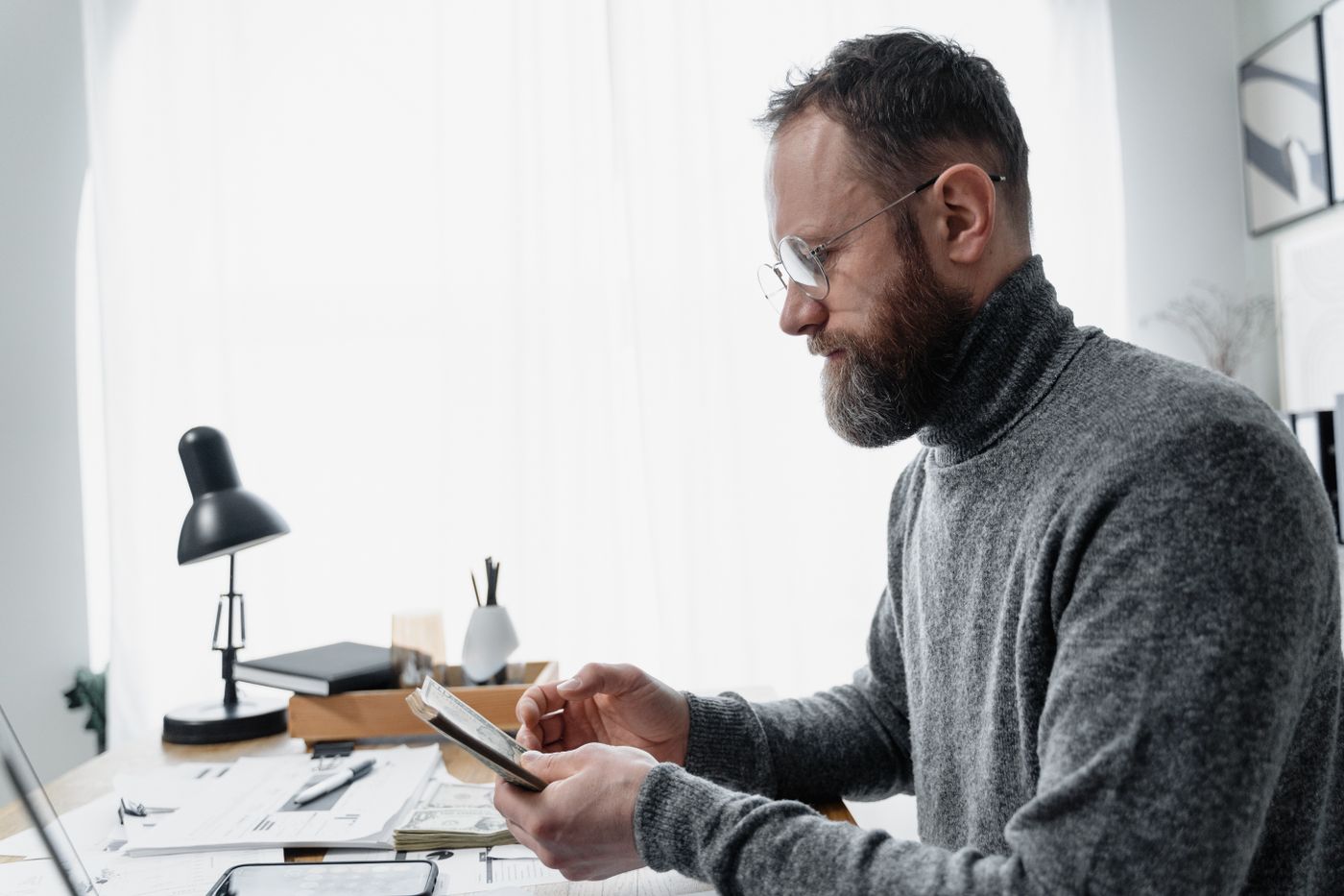 Adult male reviewing documents at a desk with a modern setup