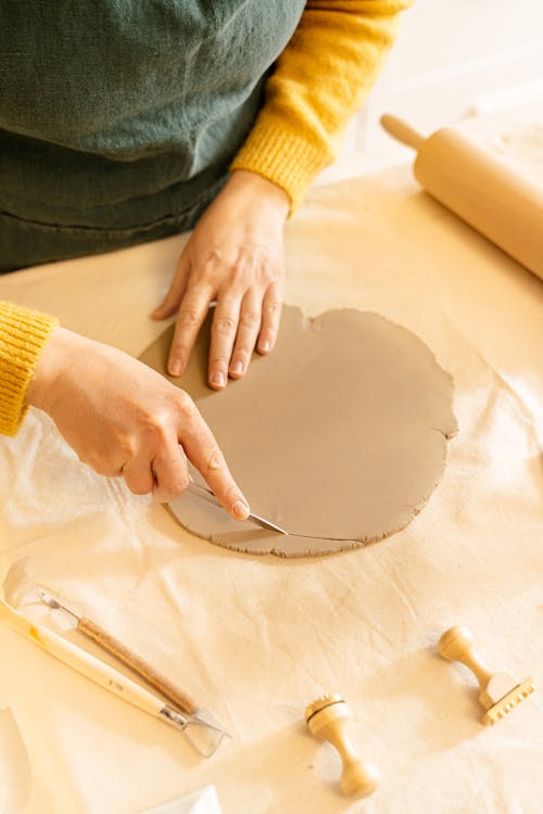 A Person Cutting a Clay Dough