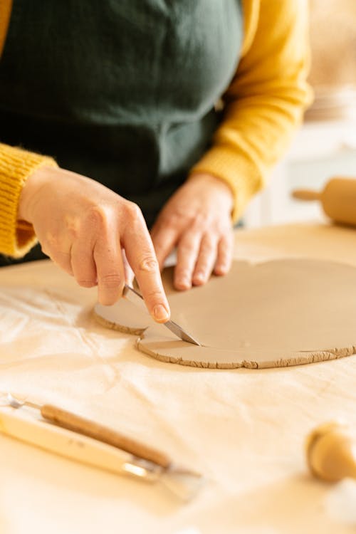 A Person Cutting a Flatten Clay