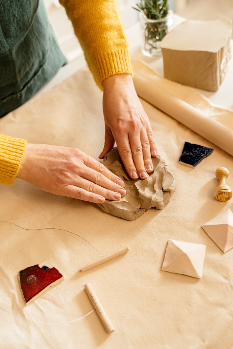 A Person Kneading A Clay