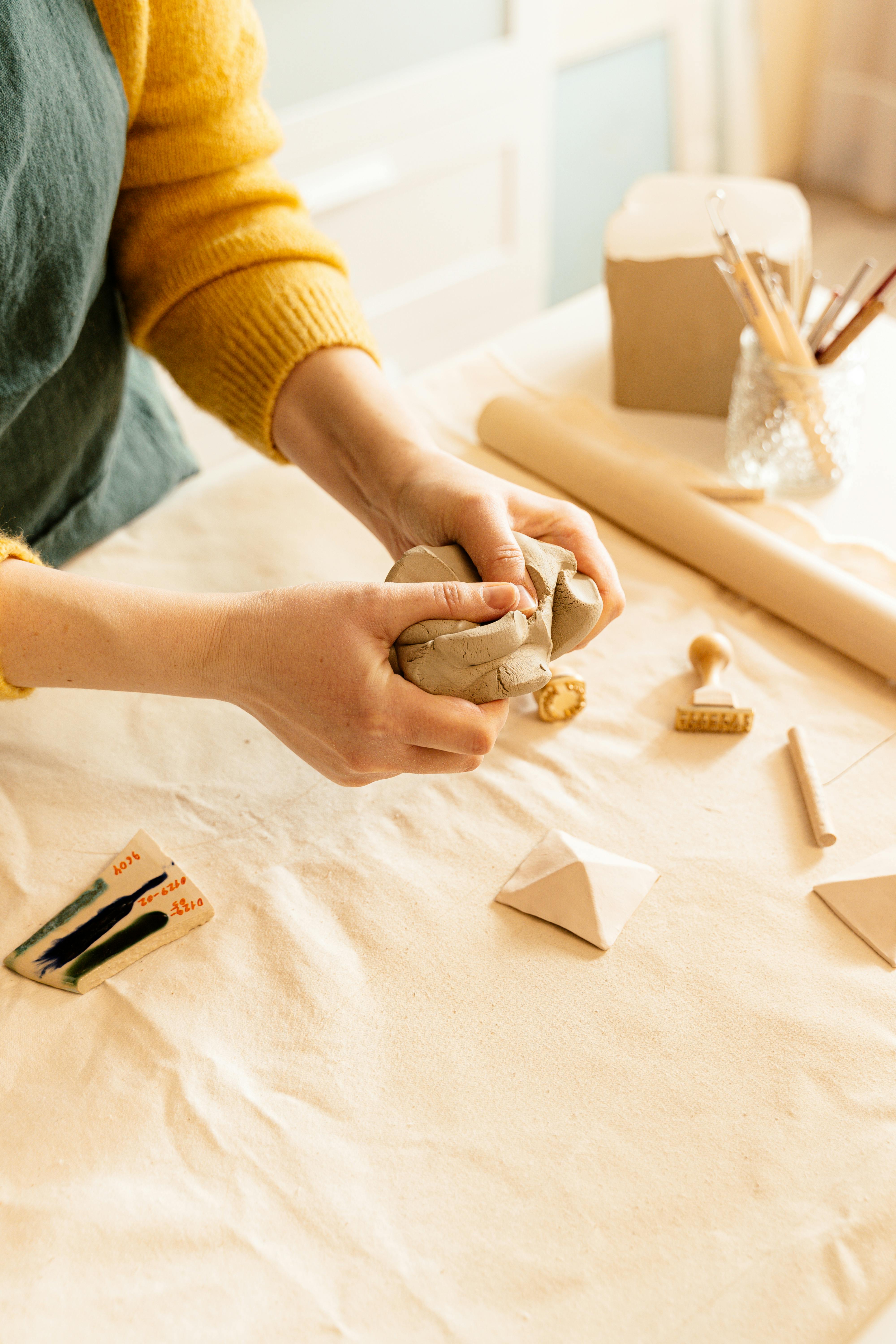 A Person Breaking a Clay Dough · Free Stock Photo