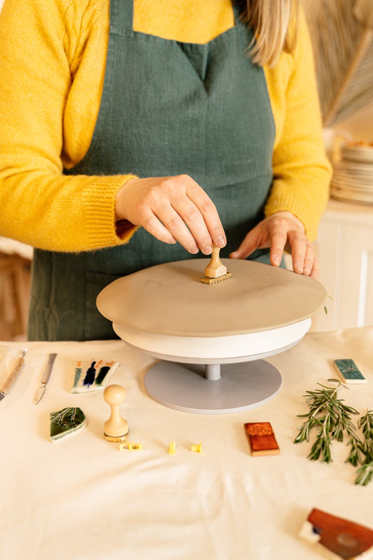 A Person Stamping A Flatten Clay Dough