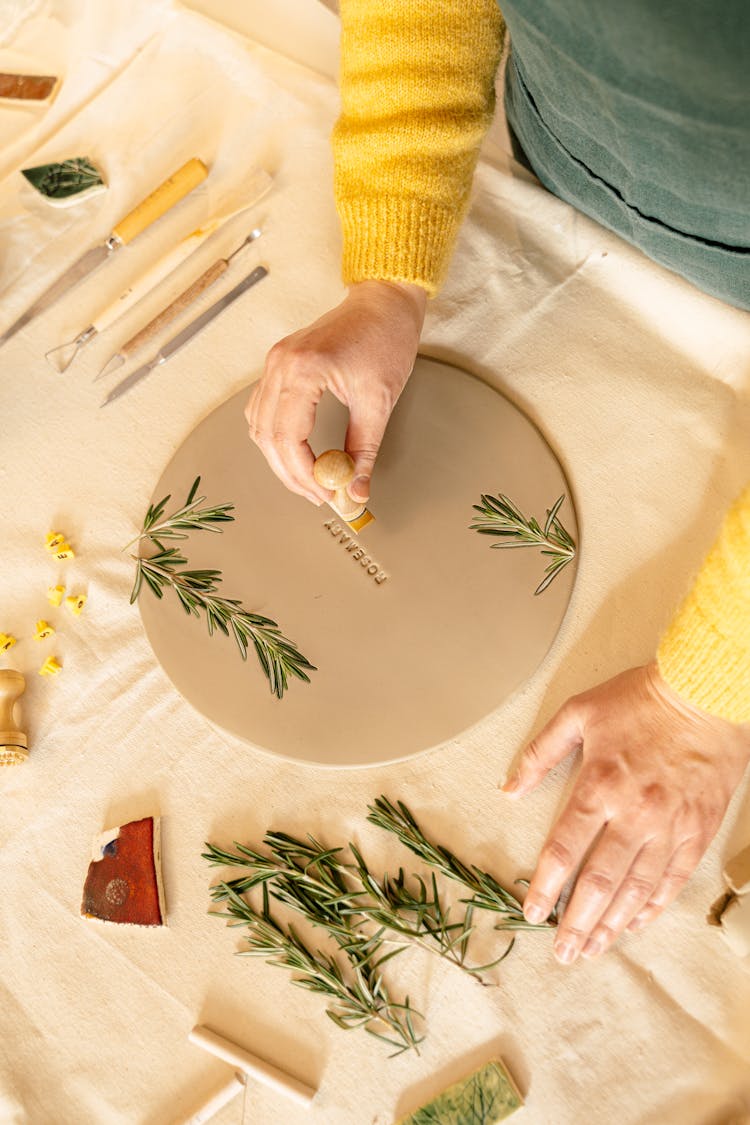 A Person Stamping A Circle Flattened Clay