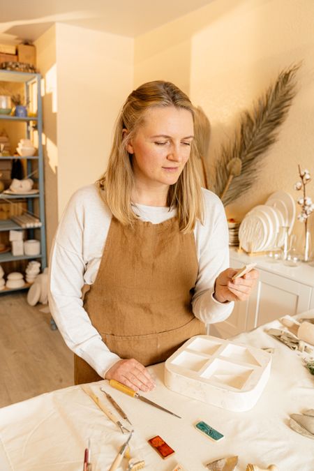 A maker glazing work at a studio bench, photo by Adventure Studio on Pexels